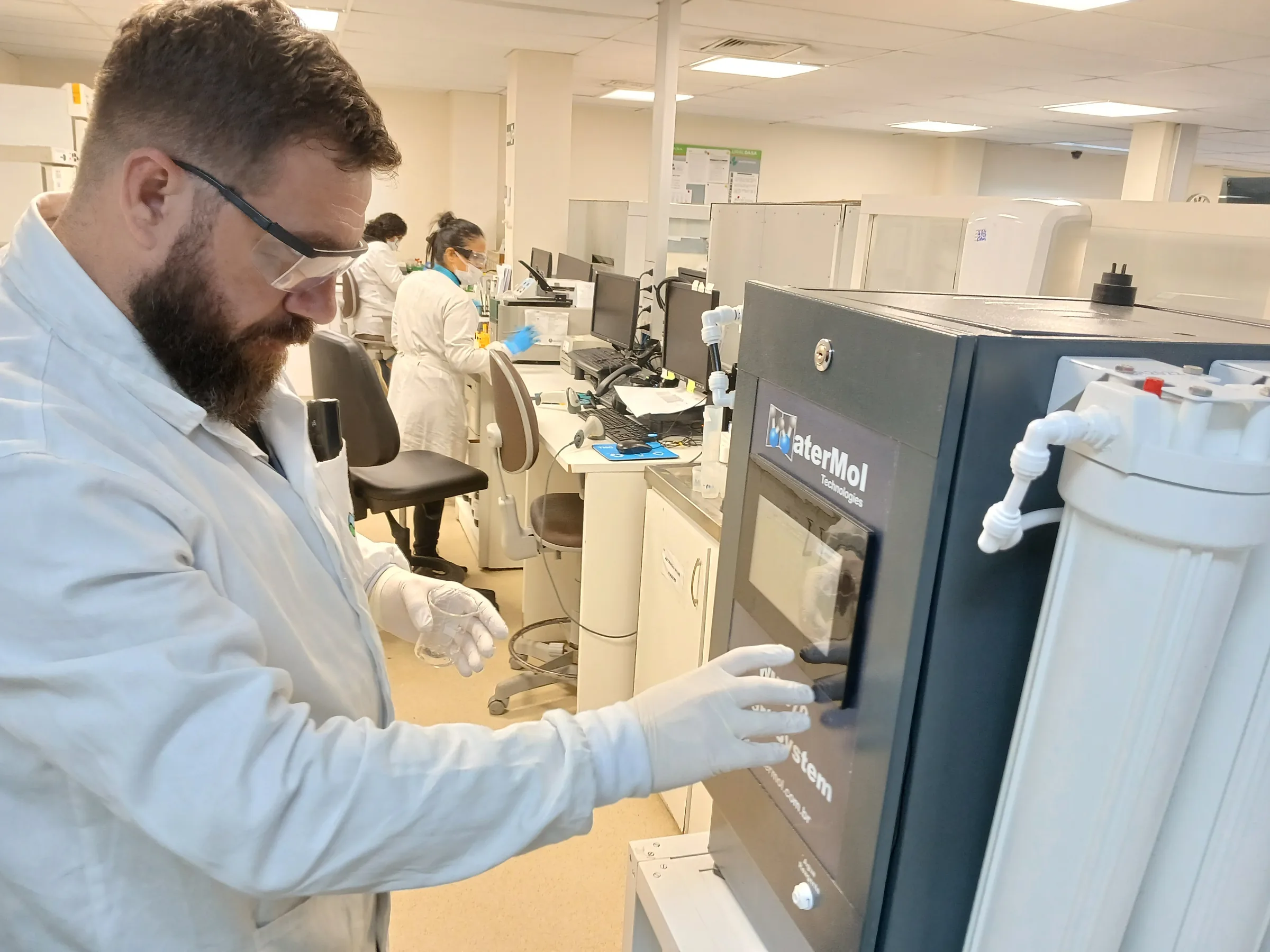 Técnico de óculos operando painel touchscreen de sistema de água ultrapura
