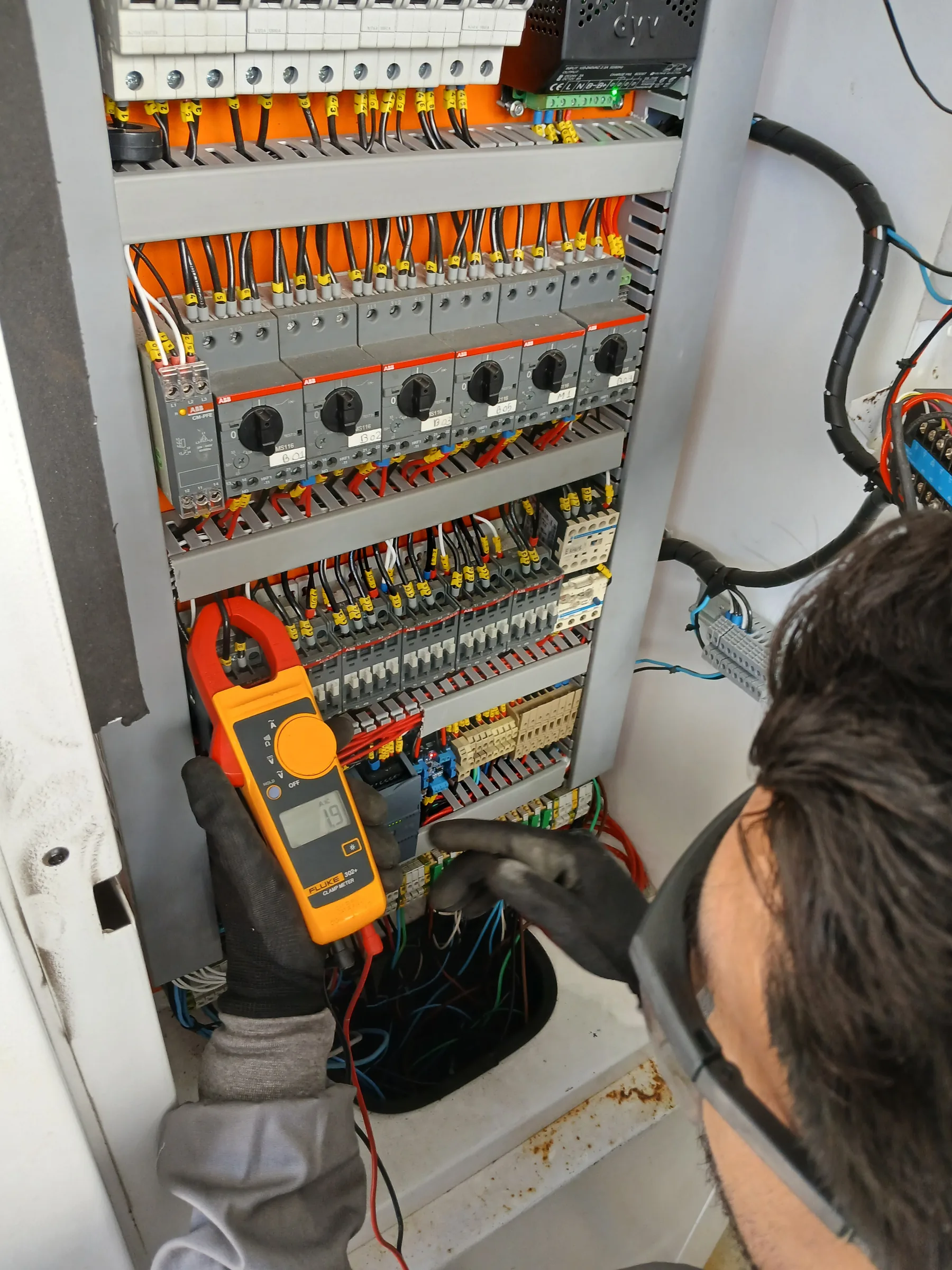 Técnico medindo continuidade em painel elétrico de sistema de reuso de água