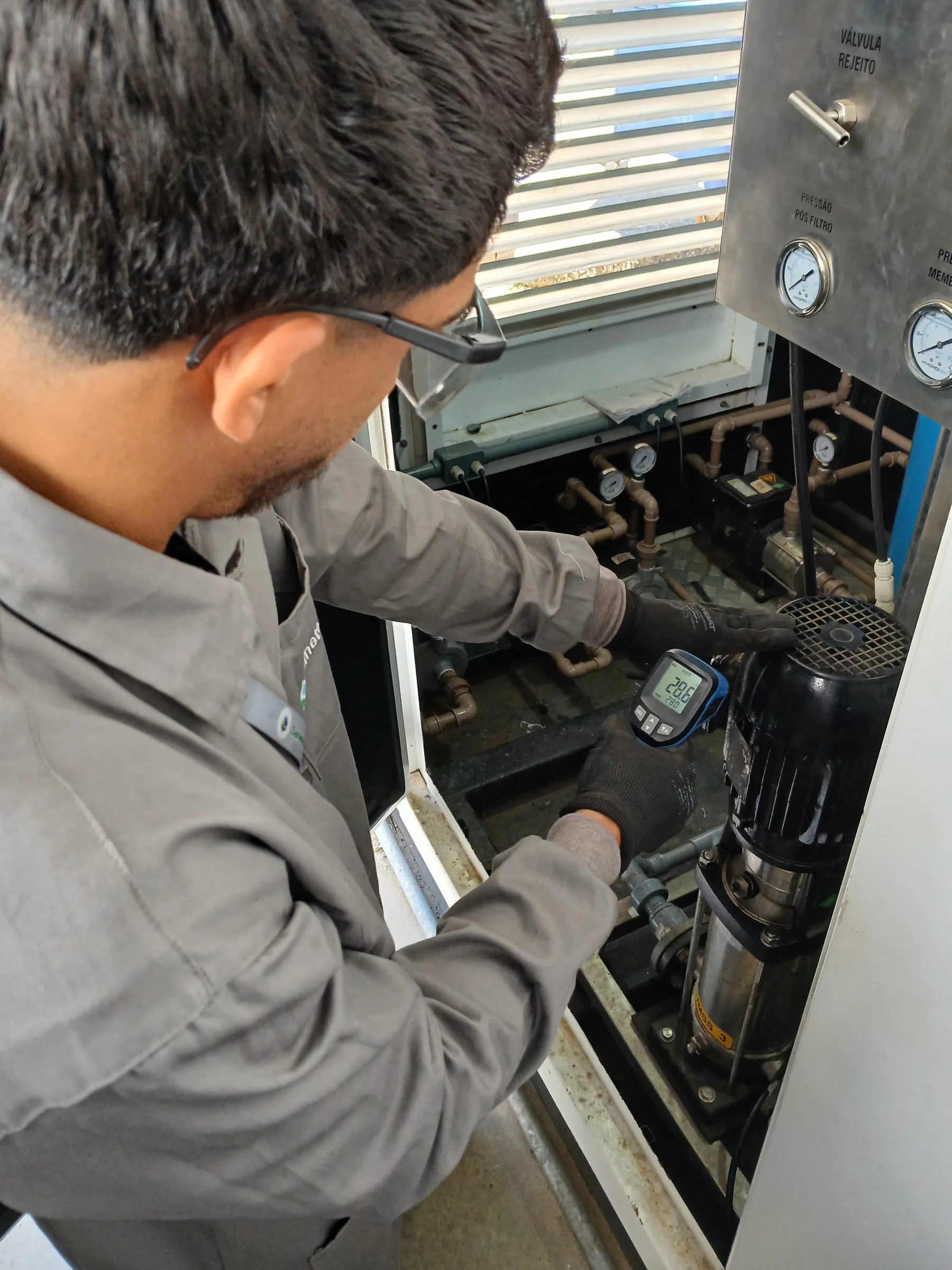 Técnico ajustando bomba de sistema de reuso de água