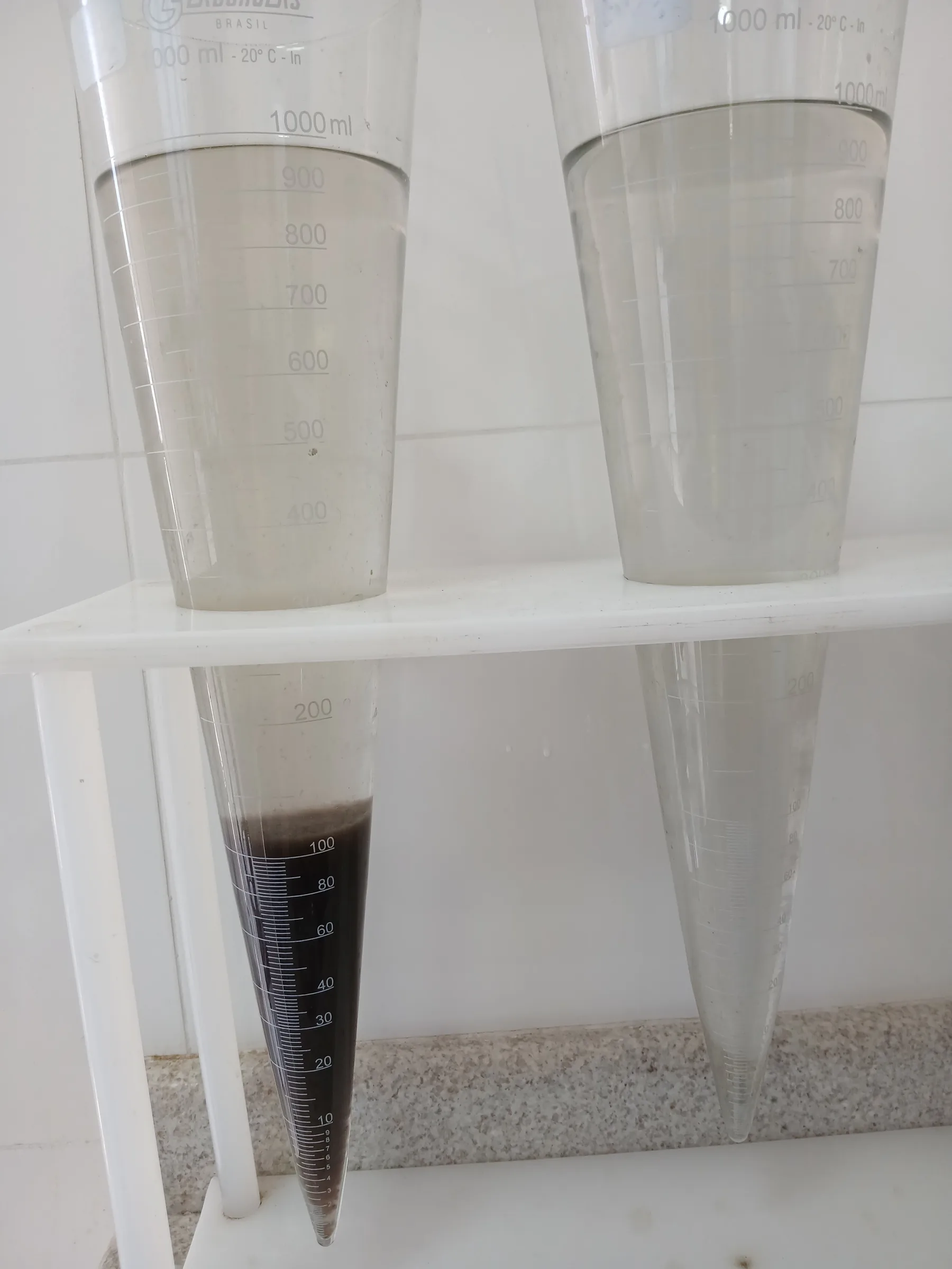 Dois cones Imhoff lado a lado mostrando lodo decantado em diferentes estágios do tratamento